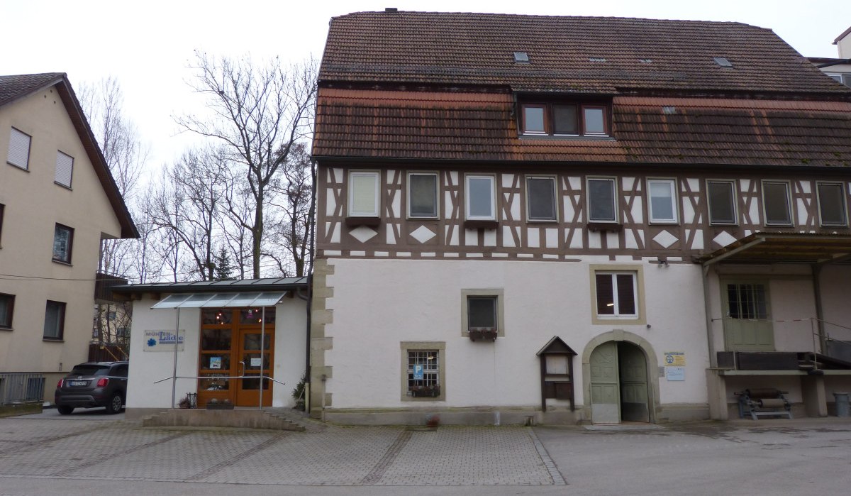 Ein Fachwerkgebäude mit einem modernen Eingang und einem kleinen Parkplatz davor. Im Hintergrund sind kahle Bäume zu sehen., © Land der 1000 Hügel - Kraichgau-Stromberg