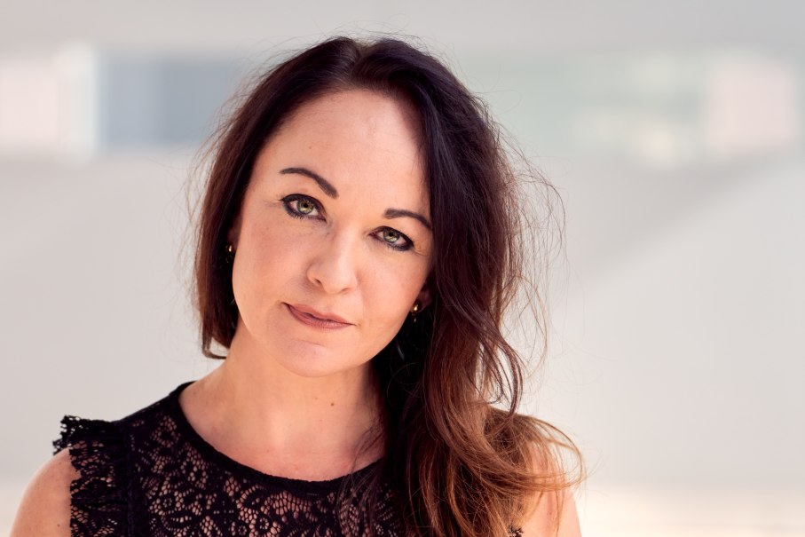 Porträt einer Frau mit dunklem Haar, die ein schwarzes Spitzenoberteil trägt. Der Hintergrund ist unscharf und hell., © copyright_Christoph Classen Porträt einer Frau mit dunklem Haar, die ein schwarzes Spitzenoberteil trägt. Der Hintergrund ist unscharf und hell., © copyright_Christoph Classen