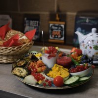 Ein reichhaltiges Fr&uuml;hst&uuml;ck mit frischem Obst, Gem&uuml;se, Dips und Brot. Eine Teekanne mit Tassen steht bereit., &copy; cZentralBar