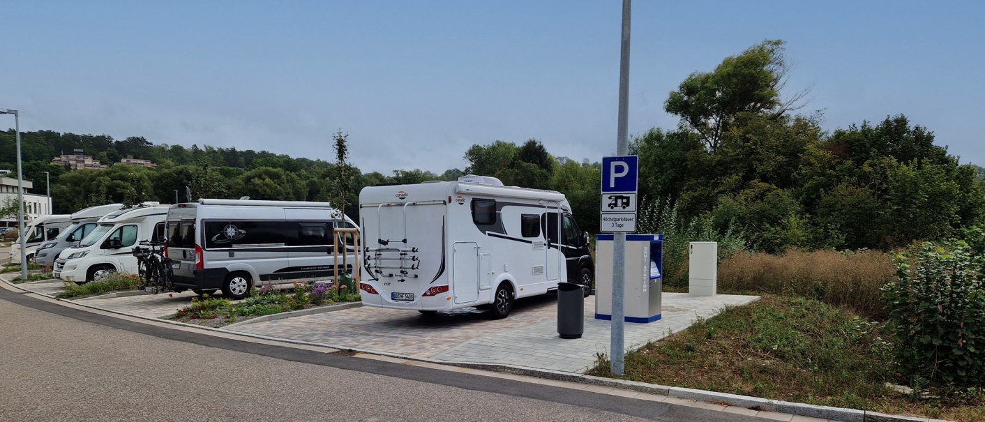 Wohnmobilstellplatz mit mehreren geparkten Wohnmobilen, umgeben von Bäumen. Ein Schild weist auf eine maximale Parkdauer von 3 Tagen hin., © Stadt Weil der Stadt