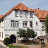 Fachwerkgebäude des Stadtmuseums Gerlingen mit rotem Ziegeldach, Bäumen und kleinem Brunnen im Vordergrund., © Stadtmuseum Gerlingen Fachwerkgebäude des Stadtmuseums Gerlingen mit rotem Ziegeldach, Bäumen und kleinem Brunnen im Vordergrund., © Stadtmuseum Gerlingen