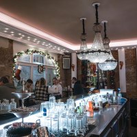 Festlich dekorierte Bar mit Kronleuchtern, G&auml;sten an der Theke und weihnachtlichem Schmuck. Gl&auml;ser und Flaschen stehen auf der Theke., &copy; SMG Stuttgart Marketing GmbH - Sarah Schmid