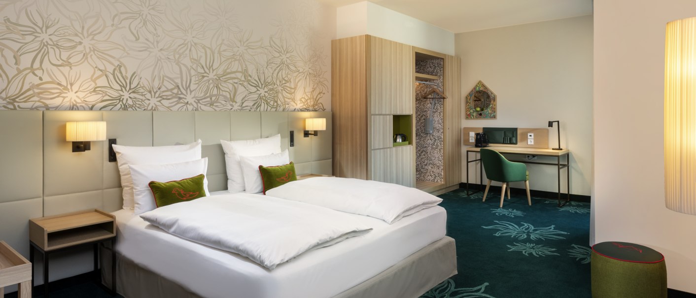 Modernes Hotelzimmer mit Doppelbett, Schreibtisch, grünem Teppich mit Blumenmuster und stilvoller Beleuchtung., © Mövenpick Hotel Stuttgart Messe & Congress Modernes Hotelzimmer mit Doppelbett, Schreibtisch, grünem Teppich mit Blumenmuster und stilvoller Beleuchtung., © Mövenpick Hotel Stuttgart Messe & Congress