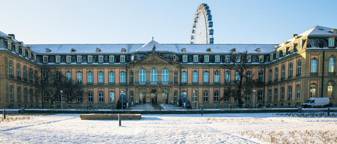 Das Neue Schloss in Stuttgart ist von Schnee bedeckt. Im Hintergrund ist ein Riesenrad zu sehen, das in den blauen Himmel ragt., &copy; Stuttgart-Marketing GmbH, Sarah Schmid