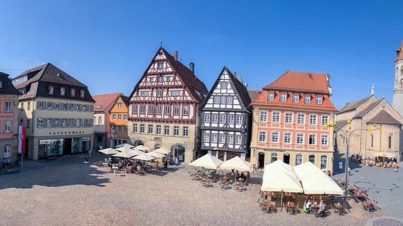 Historischer Marktplatz mit Fachwerkhäusern, Rathaus und Johanniskirche unter blauem Himmel. Menschen sitzen in Cafés und genießen die Atmosphäre., © Für die Bildrechte: Amt für Medien und Kommunikation Schwäbisch Gmünd Historischer Marktplatz mit Fachwerkhäusern, Rathaus und Johanniskirche unter blauem Himmel. Menschen sitzen in Cafés und genießen die Atmosphäre., © Für die Bildrechte: Amt für Medien und Kommunikation Schwäbisch Gmünd