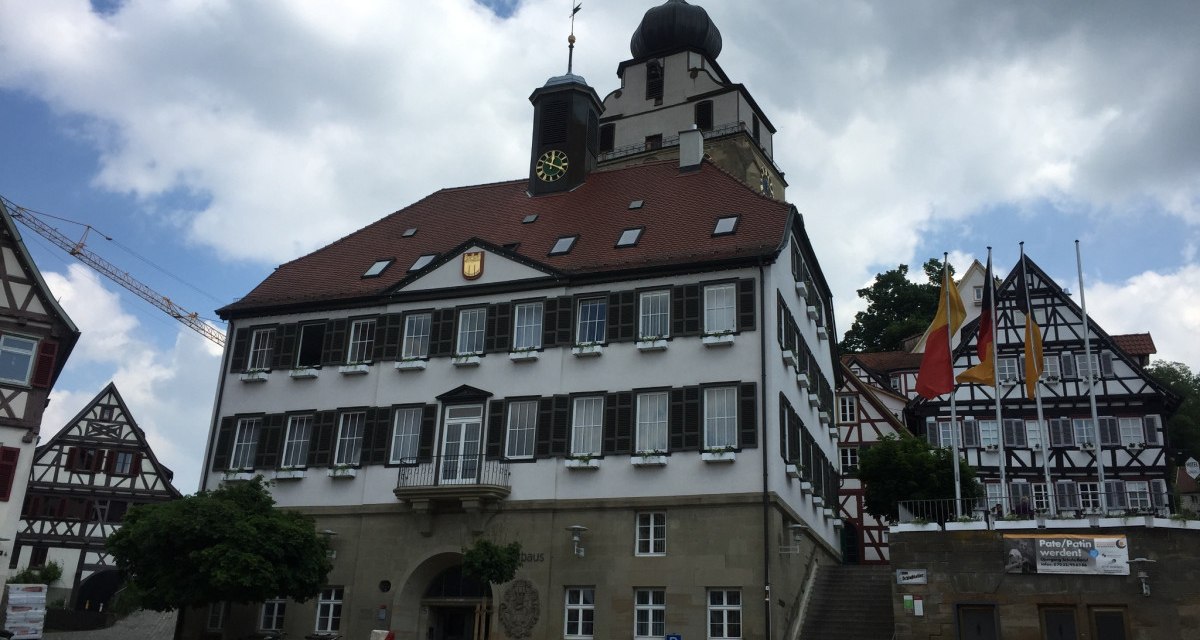 Das Rathaus von Herrenberg mit Fachwerkhäusern im Hintergrund. Vor dem Gebäude stehen leere Stühle. Der Himmel ist bewölkt., © www.pro-cycl.de Das Rathaus von Herrenberg mit Fachwerkhäusern im Hintergrund. Vor dem Gebäude stehen leere Stühle. Der Himmel ist bewölkt., © www.pro-cycl.de