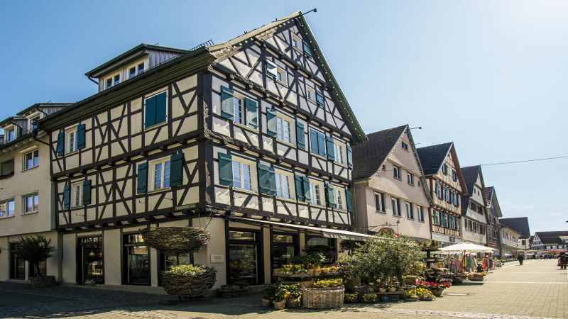 Fachwerkhäuser in der Altstadt von Kirchheim unter Teck, sonniger Tag, Geschäfte und Blumen auf der Straße., © SMG Stuttgart Marketing GmbH - Sarah Schmid