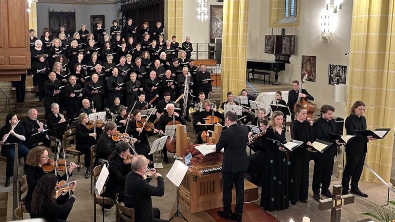 Ein Chor und Orchester führen in einer Kirche ein klassisches Musikstück auf. Der Dirigent steht vor dem Ensemble., © Evangelisches Bezirkskantorat Herrenberg