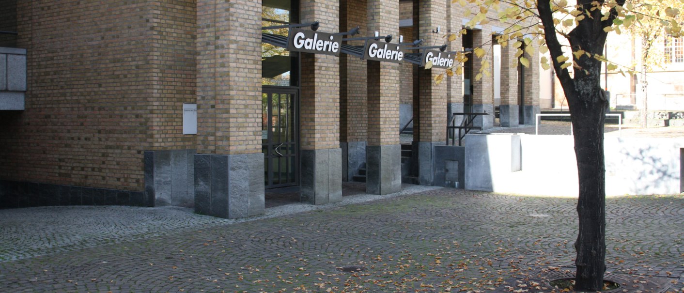 Eingang der Städtischen Galerie Fellbach mit Backsteinfassade, Glasfront und herbstlichem Baum im Vordergrund., © Galerie der Stadt Fellbach Eingang der Städtischen Galerie Fellbach mit Backsteinfassade, Glasfront und herbstlichem Baum im Vordergrund., © Galerie der Stadt Fellbach
