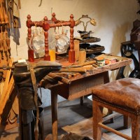 Eine alte Werkstatt im Flößermuseum Calmbach mit Werkzeugen, Lederstiefel und einem Holzhocker. An der Wand hängen zahlreiche Handwerkzeuge., © Touristik Bad Wildbad GmbH Eine alte Werkstatt im Flößermuseum Calmbach mit Werkzeugen, Lederstiefel und einem Holzhocker. An der Wand hängen zahlreiche Handwerkzeuge., © Touristik Bad Wildbad GmbH