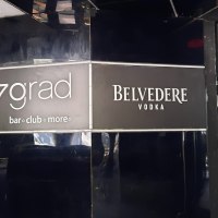 Eingang zur 7grad Bar mit schwarzem Interieur und Belvedere Vodka Werbung. Glastür mit "Ziehen"-Schild sichtbar., © SMG