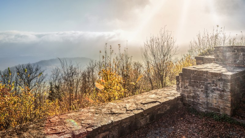 Ruinen der Burgruine Hohenstaufen, umgeben von herbstlichen Bäumen. Nebel und Sonnenstrahlen im Hintergrund schaffen eine mystische Atmosphäre., © Stuttgart-Marketing GmbH, Martina Denker Ruinen der Burgruine Hohenstaufen, umgeben von herbstlichen Bäumen. Nebel und Sonnenstrahlen im Hintergrund schaffen eine mystische Atmosphäre., © Stuttgart-Marketing GmbH, Martina Denker
