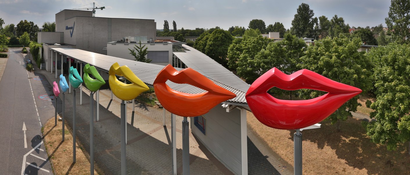 Bunte Lippen-Skulpturen in verschiedenen Farben vor der FILharmonie in Filderstadt, umgeben von B&auml;umen und einem bew&ouml;lkten Himmel., &copy; SMG, Achim Mende
