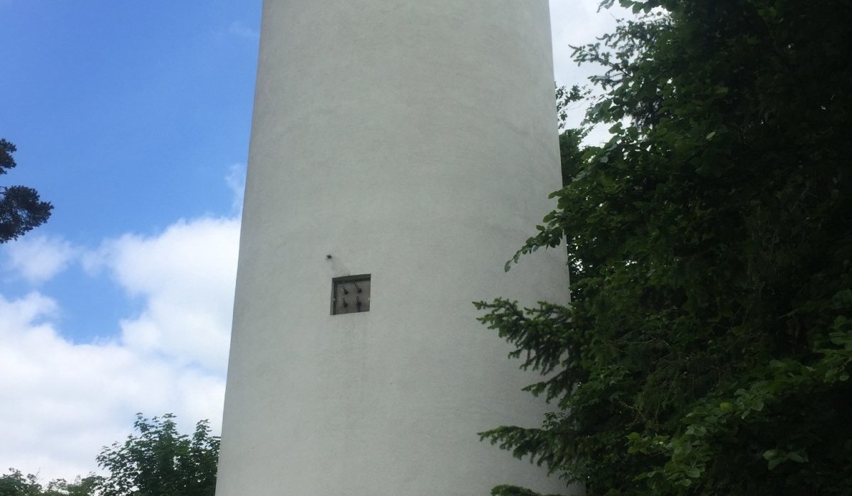 Ein wei&szlig;er, runder Aussichtsturm erhebt sich vor einem blauen Himmel, umgeben von gr&uuml;nen B&auml;umen., &copy; www.pro-cycl.de