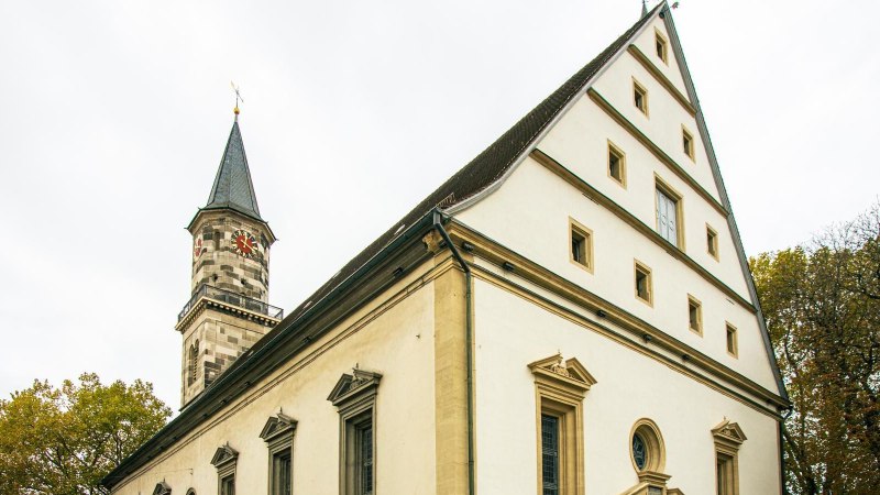 Die Stadtkirche G&ouml;ppingen mit ihrem markanten Turm und Giebeldach vor bew&ouml;lktem Himmel und herbstlichen B&auml;umen., &copy; Stuttgart-Marketing GmbH, Sarah Schmid