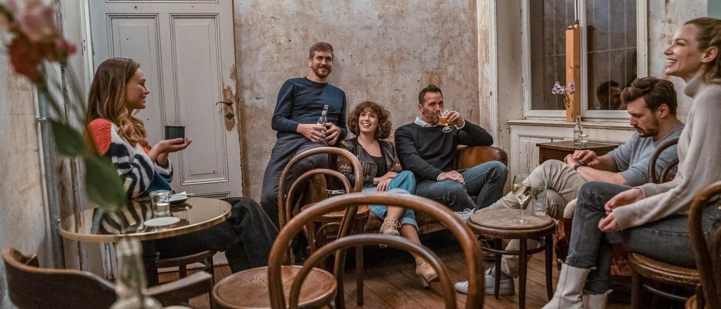 Eine Gruppe von sechs Personen sitzt in einem gemütlichen Raum mit rustikaler Einrichtung und unterhält sich entspannt., © SMG, Martina Denker Eine Gruppe von sechs Personen sitzt in einem gemütlichen Raum mit rustikaler Einrichtung und unterhält sich entspannt., © SMG, Martina Denker