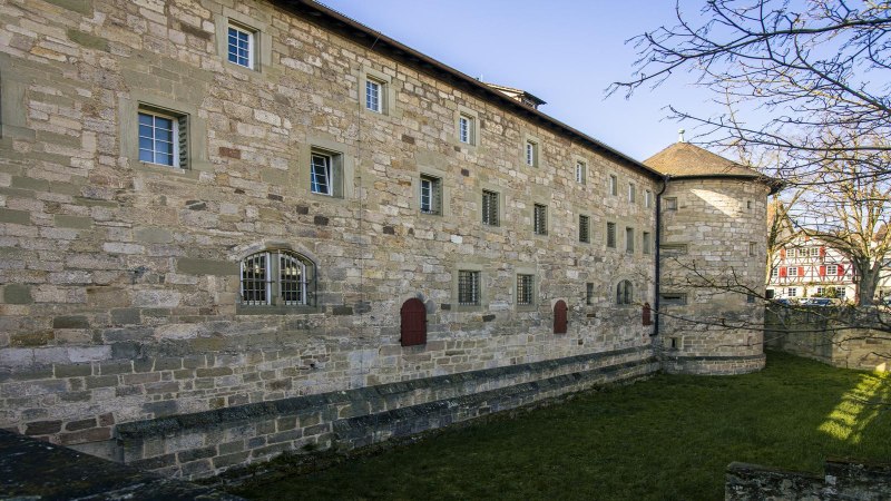 Seitenansicht des Schorndorfer Burgschlosses mit Steinmauer, Fenstern und einem Fachwerkhaus im Hintergrund., © SMG, Sarah Schmid Seitenansicht des Schorndorfer Burgschlosses mit Steinmauer, Fenstern und einem Fachwerkhaus im Hintergrund., © SMG, Sarah Schmid