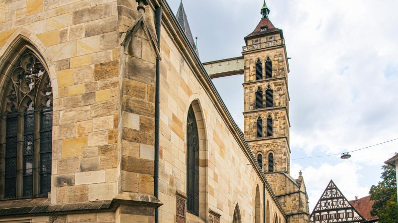 Die Stadtkirche St. Dionys in Esslingen zeigt gotische Architektur mit markanten Fenstern und einem hohen Turm. Im Hintergrund sind Fachwerkhäuser zu sehen., © Stuttgart-Marketing GmbH, Sarah Schmid Die Stadtkirche St. Dionys in Esslingen zeigt gotische Architektur mit markanten Fenstern und einem hohen Turm. Im Hintergrund sind Fachwerkhäuser zu sehen., © Stuttgart-Marketing GmbH, Sarah Schmid