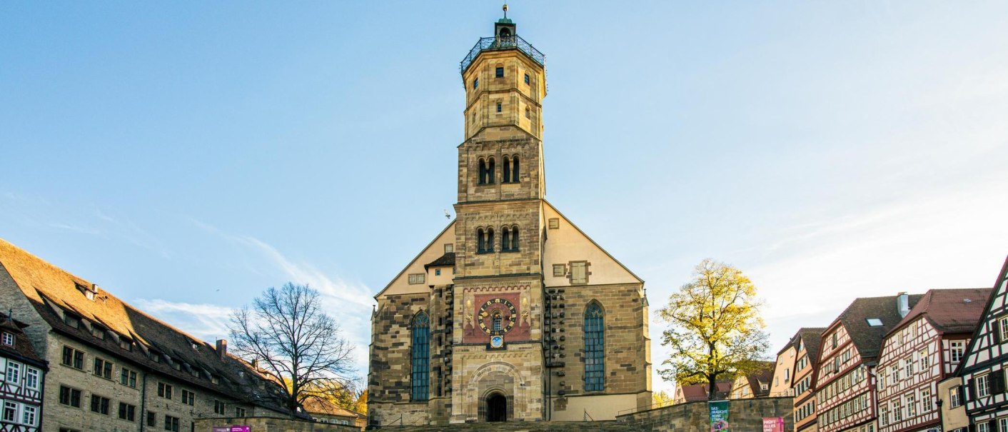 Die Kirche St. Michael in Schwäbisch Hall, umgeben von Fachwerkhäusern, erstrahlt im Sonnenlicht. Der Marktplatz ist menschenleer., © Stuttgart-Marketing GmbH, Sarah Schmid Die Kirche St. Michael in Schwäbisch Hall, umgeben von Fachwerkhäusern, erstrahlt im Sonnenlicht. Der Marktplatz ist menschenleer., © Stuttgart-Marketing GmbH, Sarah Schmid
