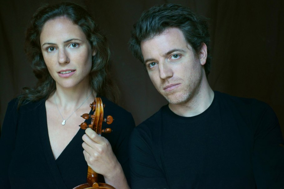Zwei Personen, eine Frau mit einer Geige und ein Mann, posieren vor einem dunklen Hintergrund. Beide tragen schwarze Kleidung., © copyright_UweNeumann