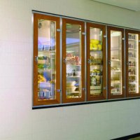 Eingang zu "karls kitchen" mit beleuchteten Glasvitrinen voller Lebensmittel und Blick in die moderne K&uuml;che., &copy; karls kitchen, Stuttgart