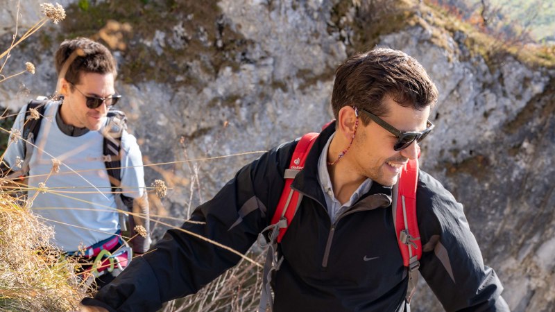 Zwei Personen klettern an einem steilen Hang. Eine Person trägt einen roten Rucksack. Ein Seil liegt auf dem Boden., © SMG, Martina Denker