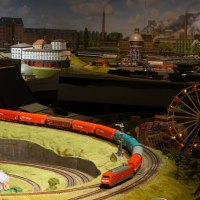Detailreiche Modelleisenbahnlandschaft mit Z&uuml;gen, Geb&auml;uden und einem Riesenrad. Die Szene zeigt eine lebendige Miniaturwelt mit Industrie- und Stadtlandschaften., &copy; PMW Winnenden e.V.