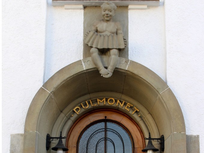 Ein steinerner Eingang mit der Aufschrift 'Pulmonet' und einer Figur, die ein Akkordeon spielt, dar&uuml;ber. Zwei Lampen flankieren die T&uuml;r., &copy; Stadt G&ouml;ppingen