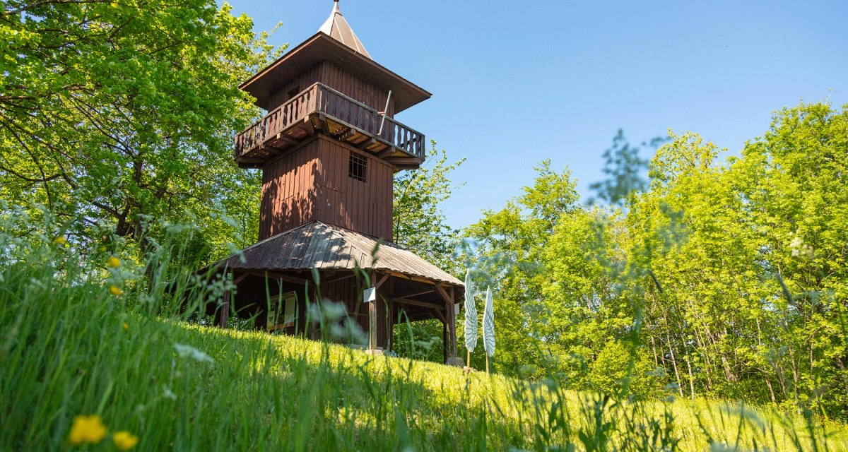 Holzturm auf Wiese, umgeben von B&auml;umen und Blumen, unter blauem Himmel., &copy; Stadt Gaildorf
