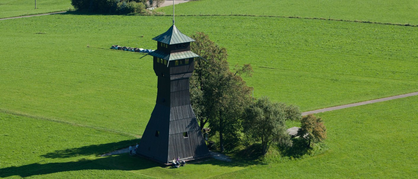 Der Hagbergturm in Gschwend steht auf einer grünen Wiese, umgeben von Bäumen. Der Turm hat ein markantes, spitzes Dach., © FVG Schwäbischer Wald Der Hagbergturm in Gschwend steht auf einer grünen Wiese, umgeben von Bäumen. Der Turm hat ein markantes, spitzes Dach., © FVG Schwäbischer Wald