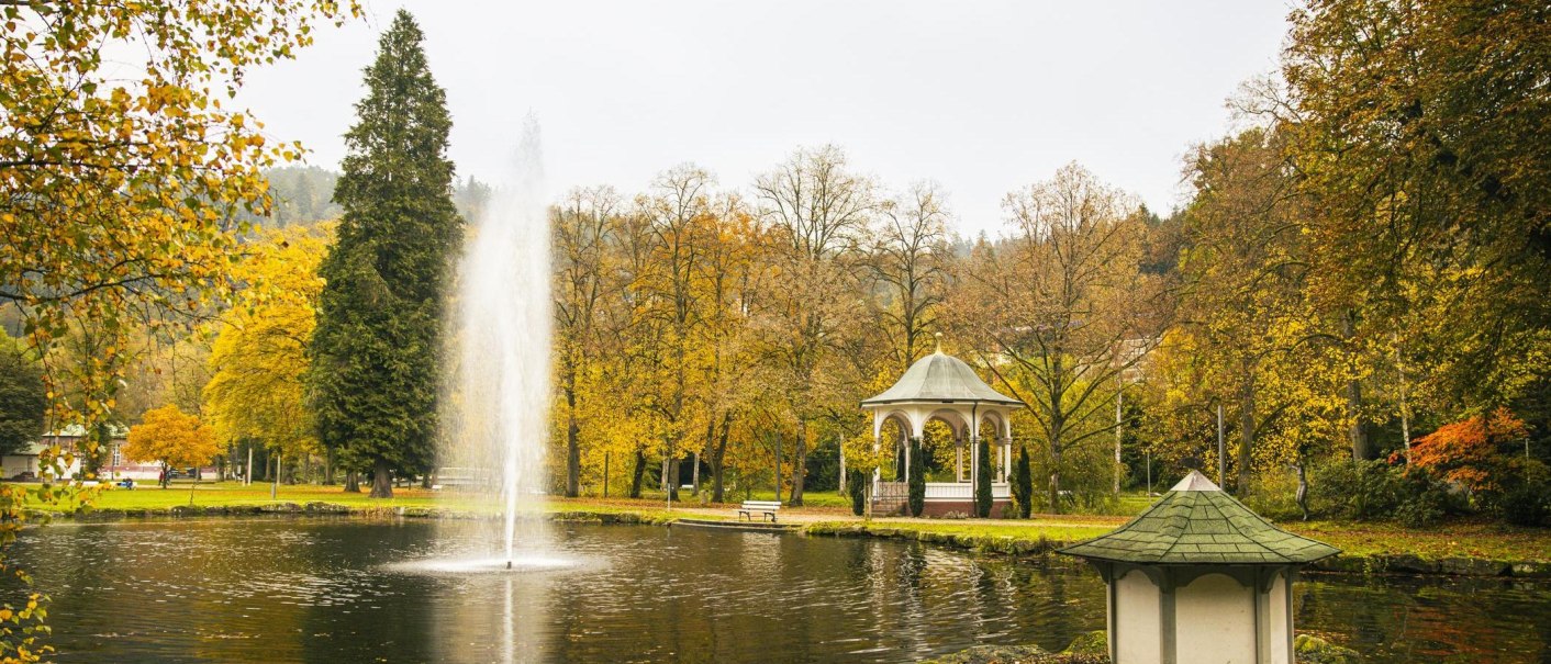 Herbstlicher Kurpark in Bad Liebenzell mit Teich, Springbrunnen und Pavillon, umgeben von buntem Laub., &copy; SMG, Sarah Schmid
