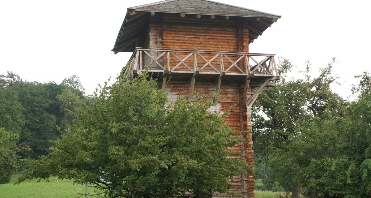 Ein hölzerner römischer Wachturm mit Balkon, umgeben von Bäumen und Wiesen. Der Turm hat ein spitzes Dach und steht in einer grünen Landschaft., © Remstal Tourismus e.V. Ein hölzerner römischer Wachturm mit Balkon, umgeben von Bäumen und Wiesen. Der Turm hat ein spitzes Dach und steht in einer grünen Landschaft., © Remstal Tourismus e.V.