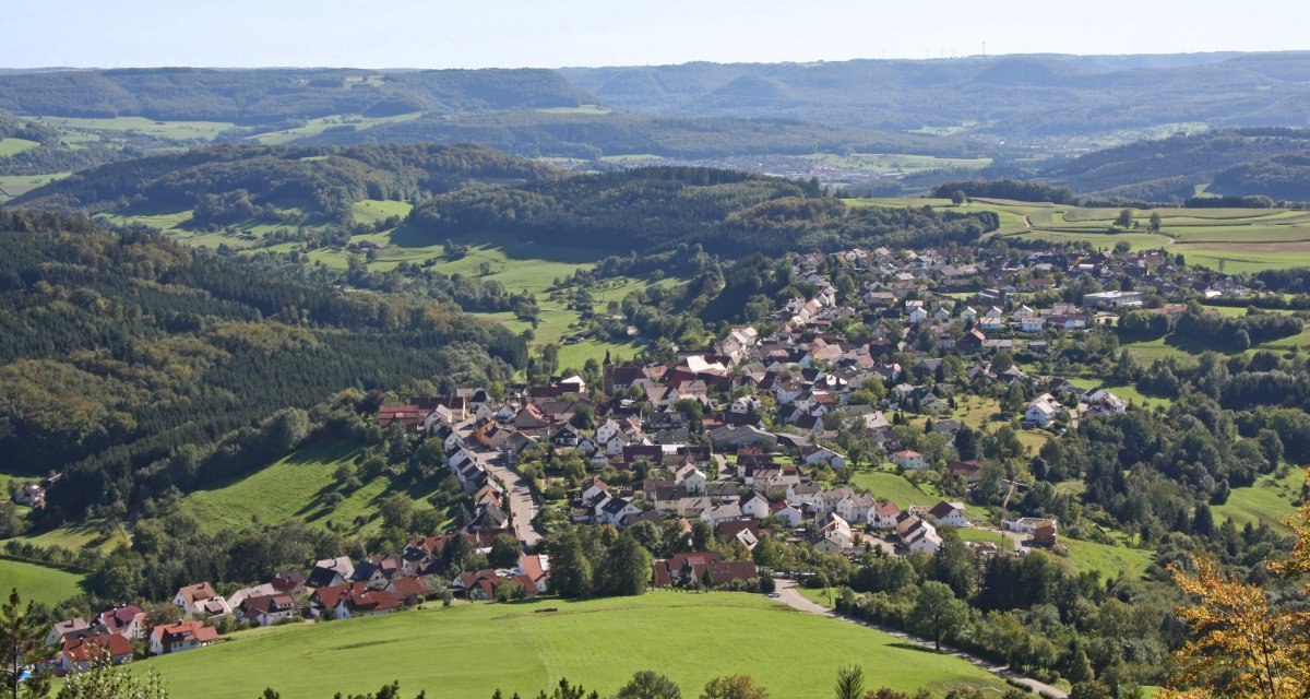 Luftaufnahme von Wissgoldingen, eingebettet in eine h&uuml;gelige Landschaft mit W&auml;ldern und Feldern, unter einem klaren blauen Himmel., &copy; Foto: Frieder Kopper
