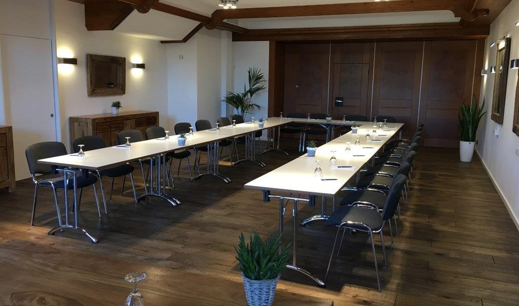 Moderner Tagungsraum mit U-förmiger Tischanordnung, Stühlen, Holzboden und Pflanzen. Dezente Beleuchtung und Holzelemente an der Decke., © TOMAS Moderner Tagungsraum mit U-förmiger Tischanordnung, Stühlen, Holzboden und Pflanzen. Dezente Beleuchtung und Holzelemente an der Decke., © TOMAS