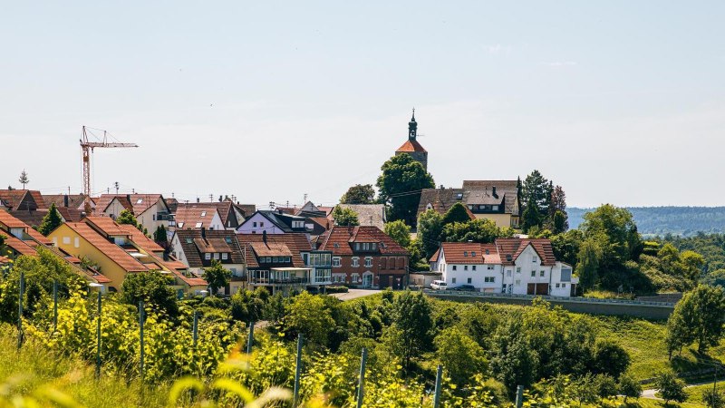 Blick auf Winnenden mit Kirche und Baukran, umgeben von grüner Landschaft und Weinbergen unter blauem Himmel., © Stuttgart-Marketing GmbH, Sarah Schmid Blick auf Winnenden mit Kirche und Baukran, umgeben von grüner Landschaft und Weinbergen unter blauem Himmel., © Stuttgart-Marketing GmbH, Sarah Schmid