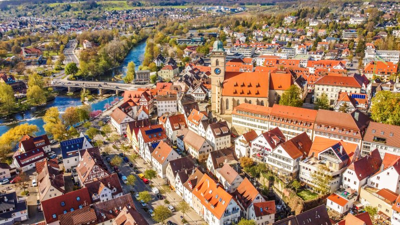 Luftaufnahme von Nürtingen im Frühling. Rote Dächer, eine Kirche und ein Fluss prägen das Stadtbild. Bäume blühen, die Landschaft ist grün., © Daniel Jüptner Luftaufnahme von Nürtingen im Frühling. Rote Dächer, eine Kirche und ein Fluss prägen das Stadtbild. Bäume blühen, die Landschaft ist grün., © Daniel Jüptner