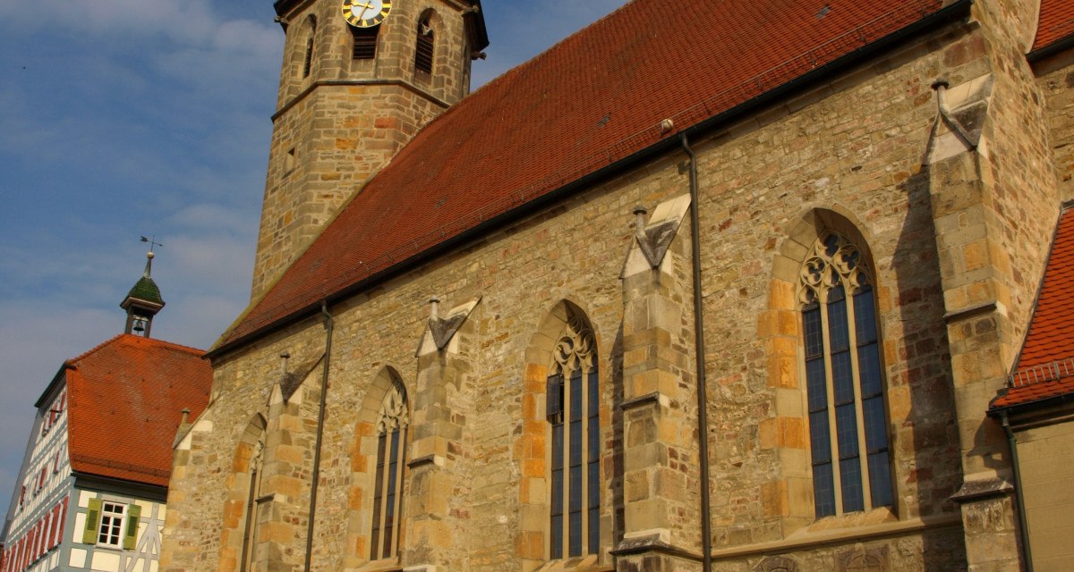 Die Evangelische Martinskirche mit gotischen Fenstern und einem Turm mit Uhr vor blauem Himmel., © Land der 1000 Hügel - Kraichgau-Stromberg