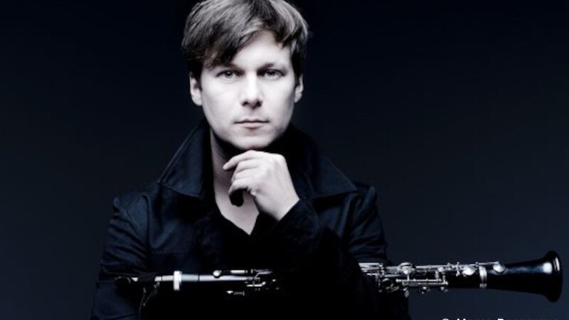 Ein Mann in dunkler Kleidung hält eine Klarinette und blickt ernst in die Kamera. Der Hintergrund ist dunkel gehalten., © Kultur- und Sportamt Stadt Bietigheim-Bissingen Ein Mann in dunkler Kleidung hält eine Klarinette und blickt ernst in die Kamera. Der Hintergrund ist dunkel gehalten., © Kultur- und Sportamt Stadt Bietigheim-Bissingen