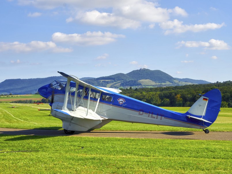 Oldtimer-Flugzeuge beim Oldtimer-Fliegertreffen auf der Hahnweide mit der Burg Teck und dem Albtrauf im Hintergrund., &copy; Fliegergruppe Wolf Hirth e. V.