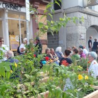 Menschen genie&szlig;en einen urbanen Garten vor einem Geb&auml;ude mit der Aufschrift 'Oberwelt'. Es herrscht eine entspannte Atmosph&auml;re., &copy; Oberwelt e.V.