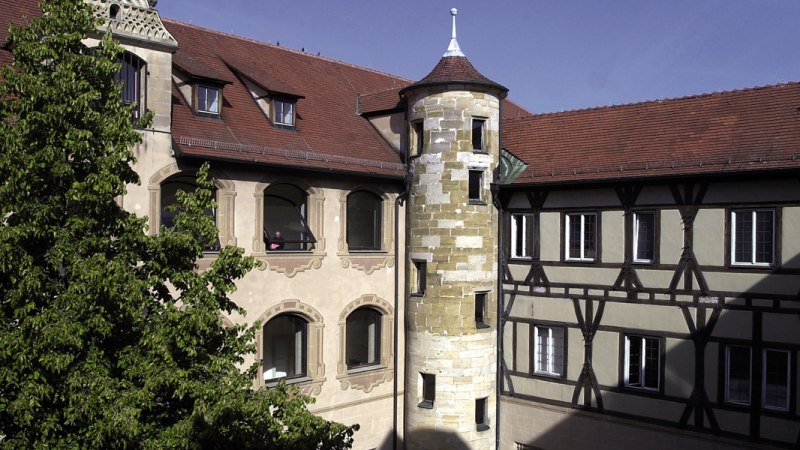 Innenhof von Schloss Göppingen mit Fachwerkfassade, Turm und Baum im Vordergrund., © Stuttgart-Marketing GmbH