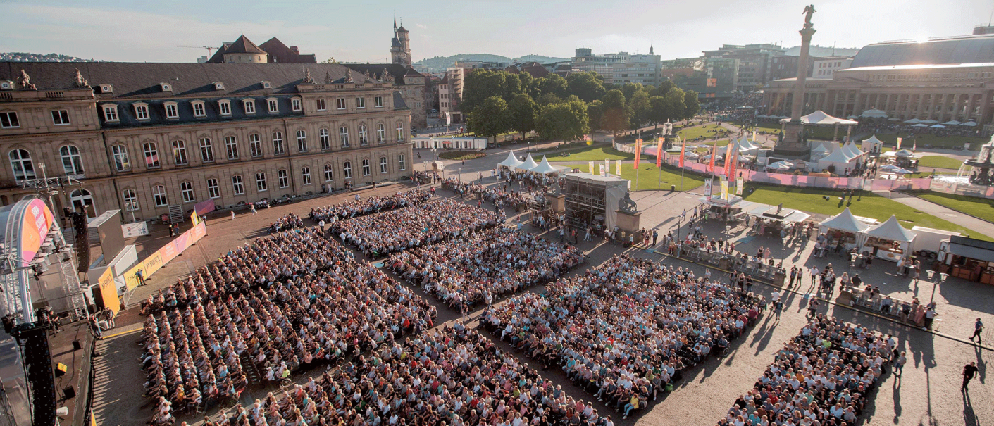 Luftaufnahme des SWR Sommerfestivals auf dem Schlossplatz Stuttgart. Viele Menschen sitzen vor einer Bühne, umgeben von historischen Gebäuden und Grünflächen., © SWR, Markus Palmer Luftaufnahme des SWR Sommerfestivals auf dem Schlossplatz Stuttgart. Viele Menschen sitzen vor einer Bühne, umgeben von historischen Gebäuden und Grünflächen., © SWR, Markus Palmer