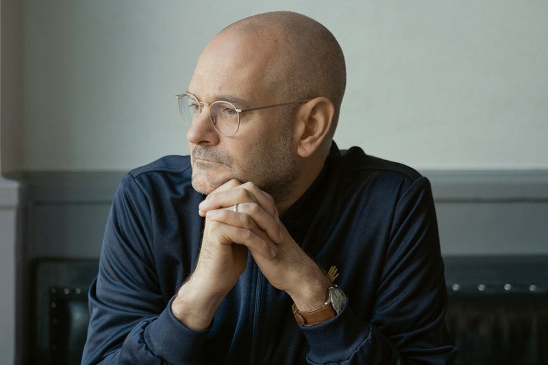 Ein nachdenklicher Mann mit Brille und Glatze sitzt mit gefalteten Händen und blickt zur Seite., © Kulturamt der Stadt Esslingen am Neckar