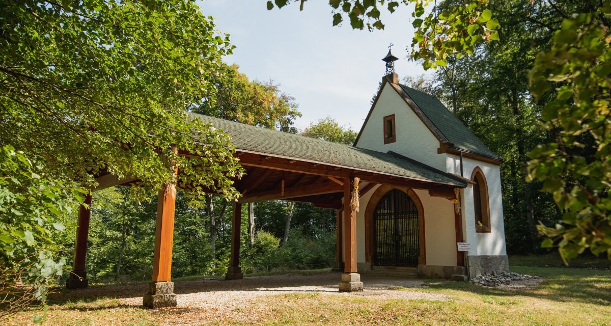 Die Bernharduskapelle steht im Wald, umgeben von Bäumen. Sie hat einen überdachten Vorbau und ein grünes Dach., © Remstal Tourismus e.V. Foto Bebop Media Die Bernharduskapelle steht im Wald, umgeben von Bäumen. Sie hat einen überdachten Vorbau und ein grünes Dach., © Remstal Tourismus e.V. Foto Bebop Media
