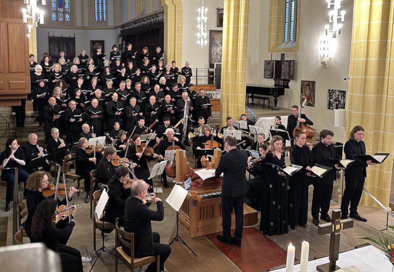 Ein Chor und Orchester führen in einer Kirche ein klassisches Musikstück auf. Der Dirigent steht vor dem Ensemble., © Evangelisches Bezirkskantorat Herrenberg