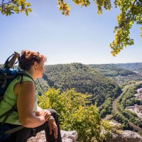 Frau mit Rucksack genießt den Ausblick vom Anwandfelsen auf Geislingen und das umliegende bewaldete Tal., © Stadt Geislingen an der Steige