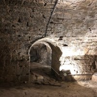 Ein steinerner Gew&ouml;lbekeller mit einem beleuchteten Durchgang. Die W&auml;nde und Decke bestehen aus grobem Mauerwerk., &copy; Eigenbetrieb Tourismus und Citymanagement Schorndorf