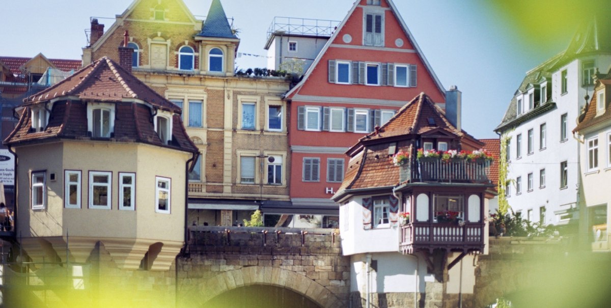 Historische Gebäude auf der Inneren Brücke in Esslingen mit Fachwerk und Erkern, umgeben von grünen Blättern im Vordergrund., © Esslinger Stadtmarketing & Tourismus GmbH Historische Gebäude auf der Inneren Brücke in Esslingen mit Fachwerk und Erkern, umgeben von grünen Blättern im Vordergrund., © Esslinger Stadtmarketing & Tourismus GmbH