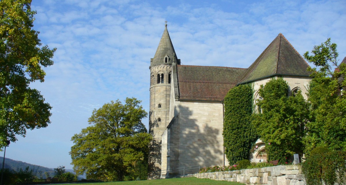 Das Bild zeigt das Kloster Lorch mit einem markanten Turm, umgeben von Bäumen und einer Wiese unter blauem Himmel., © Remstal Tourismus e.V.