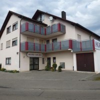 Das Hotel Gruber in Schorndorf zeigt eine helle Fassade mit roten Balkonen und einem Eingangsschild. Es liegt an einer ruhigen Straße., © Hotel Gruber